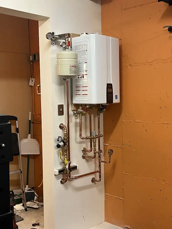 Plumbing technician inspecting water heater connections in Mukwonago